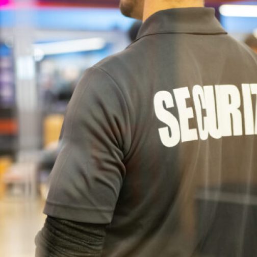 A closeup shot of a security guard inside a commercial building with reflection light in window reflecting light.